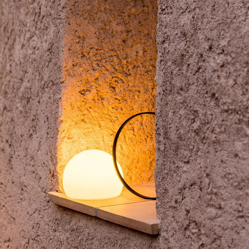 Lit in a rough plaster niche above a narrow timber ledge