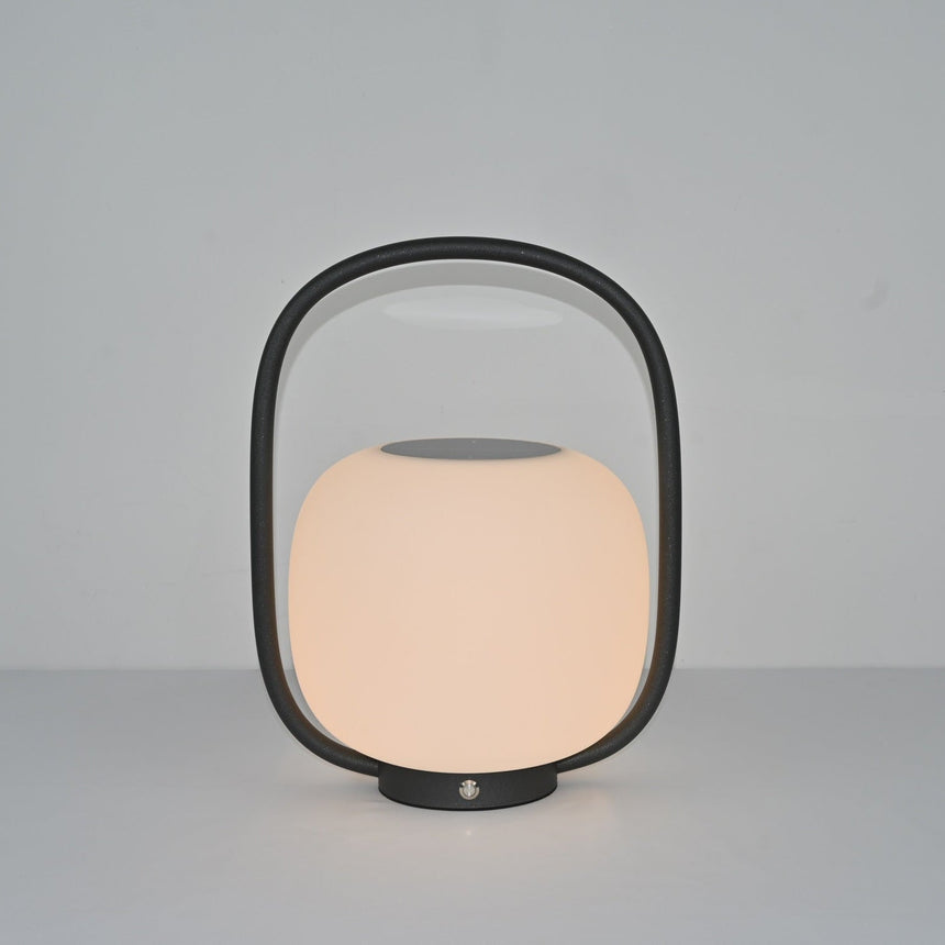 The lamp lit at a warm setting, the globe glowing inside the dark arch