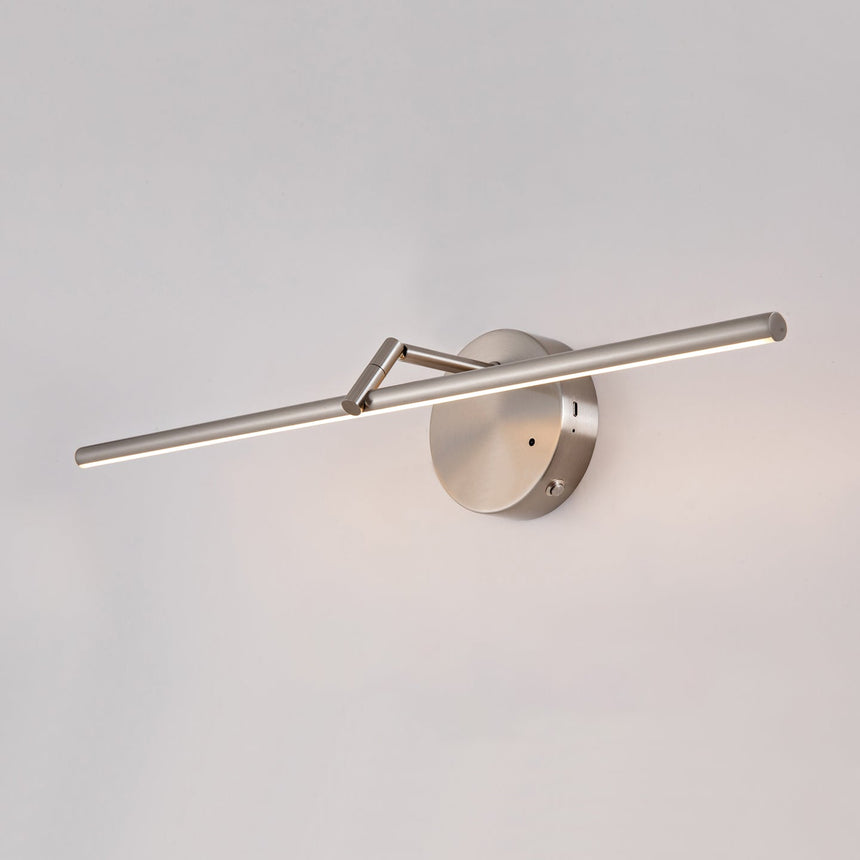 The brushed nickel rod and its round mount seen at an angle on a pale wall