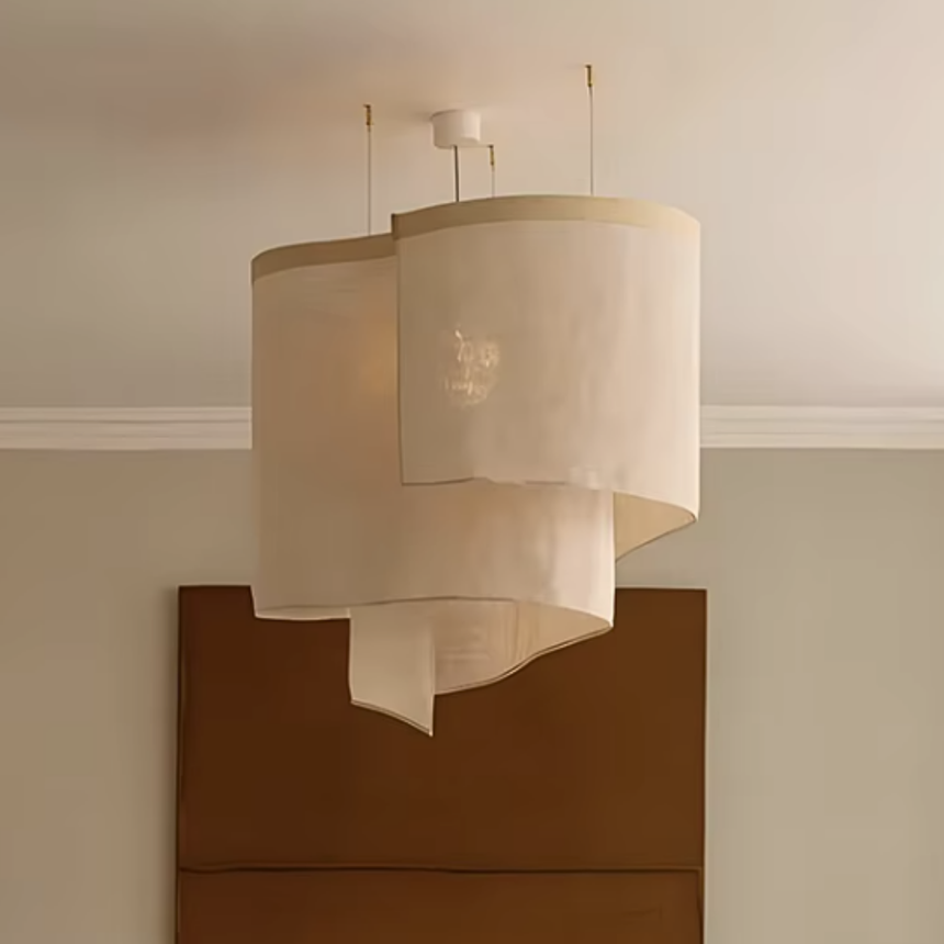 Oversized ceiling light in overlapping beige fabric shades above a sideboard