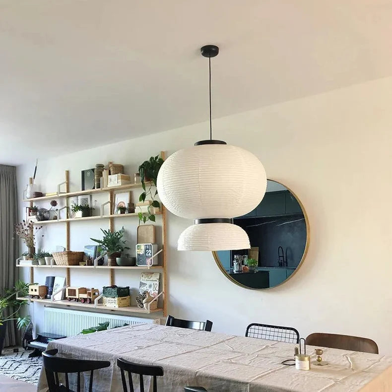 Rice paper lantern hung above a dining table beside a round mirror