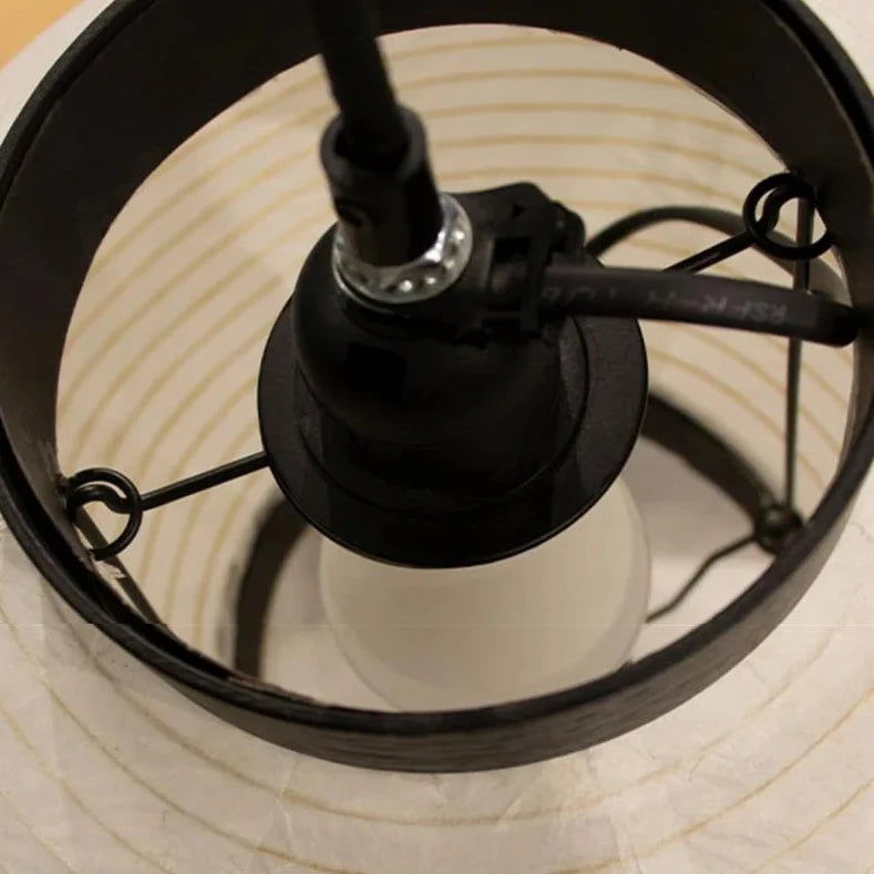 Detail of the dark iron ceiling fitting inside the paper shade