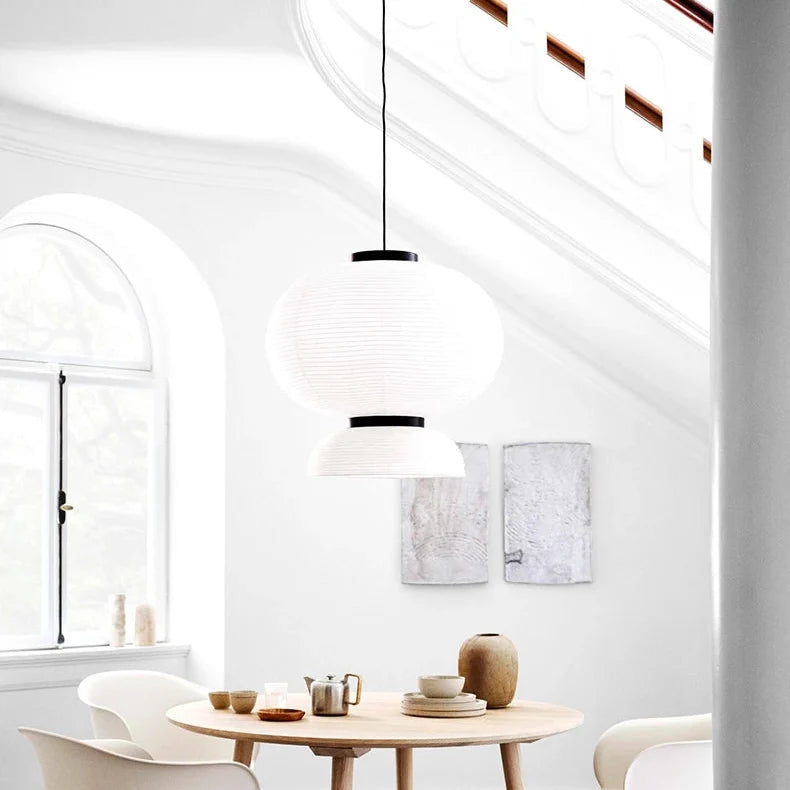 Rice paper lantern hung in a white room with an arched window