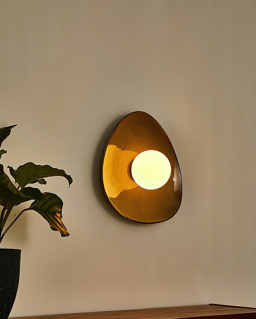 The pebble light glowing amber in the evening beside a plant