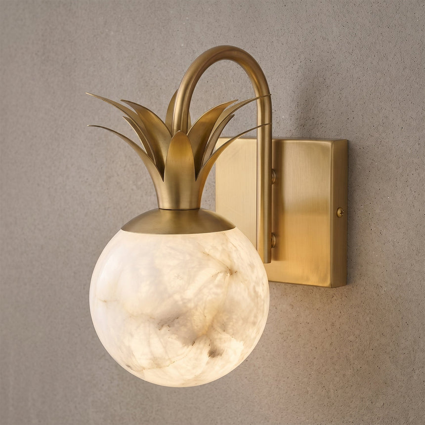 Close view of the gold leaves curling above the lit stone globe