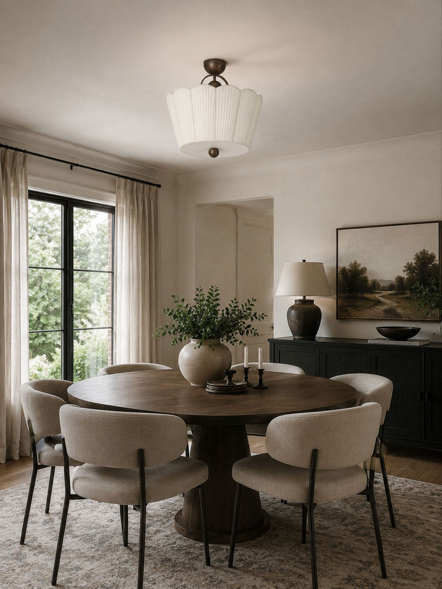 Pleated ceiling light above a round dining table with curved chairs and a window