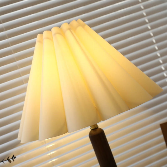 The lit pleats of the linen shade seen close, fold by fold