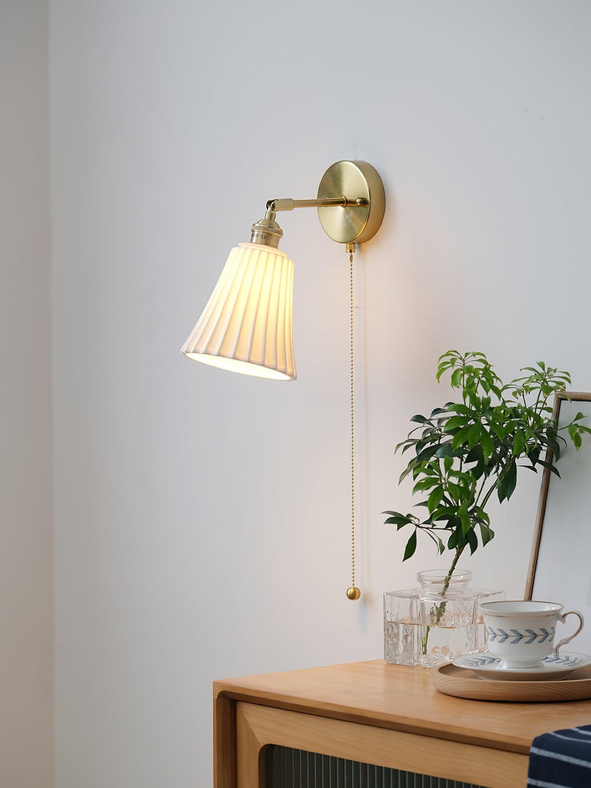 The sconce above a nightstand, seen small against the wall