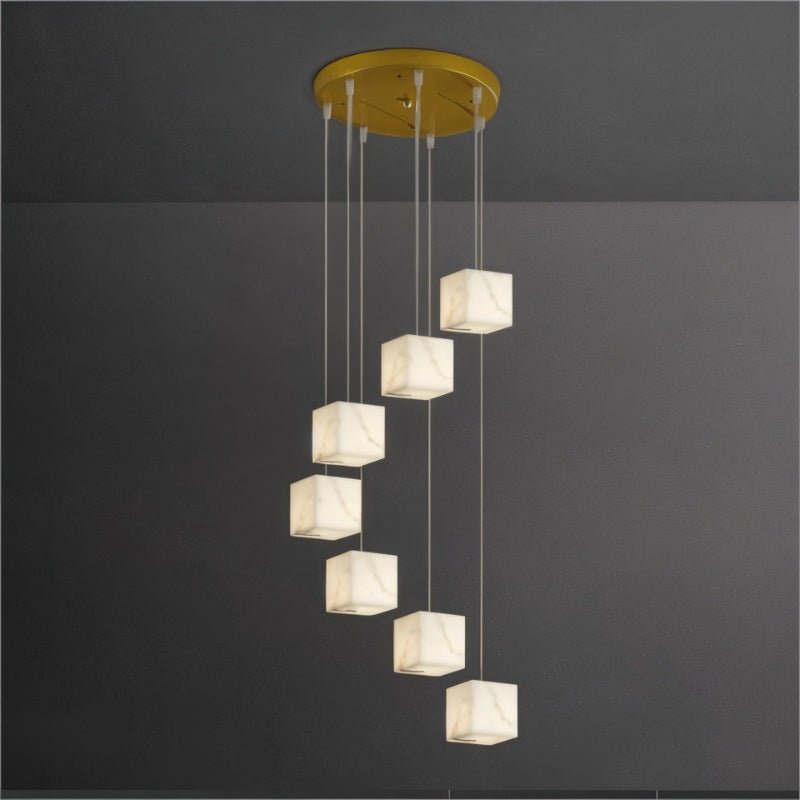A spiral of lit cubes falling from a round brass plate on long cables