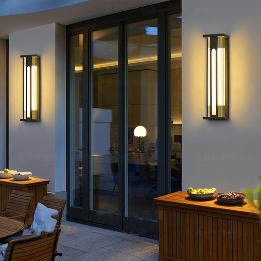 Lanterns lit beside glass patio doors above an outdoor table and a wood cabinet