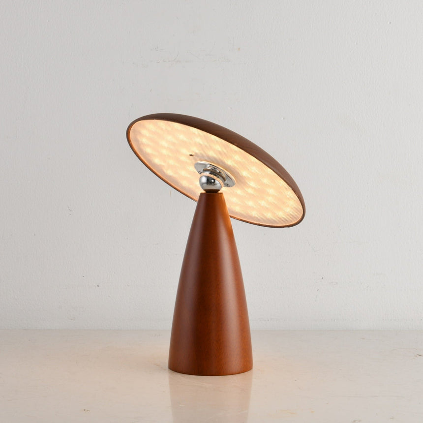 Portable table lamp with the disc tilted and lit