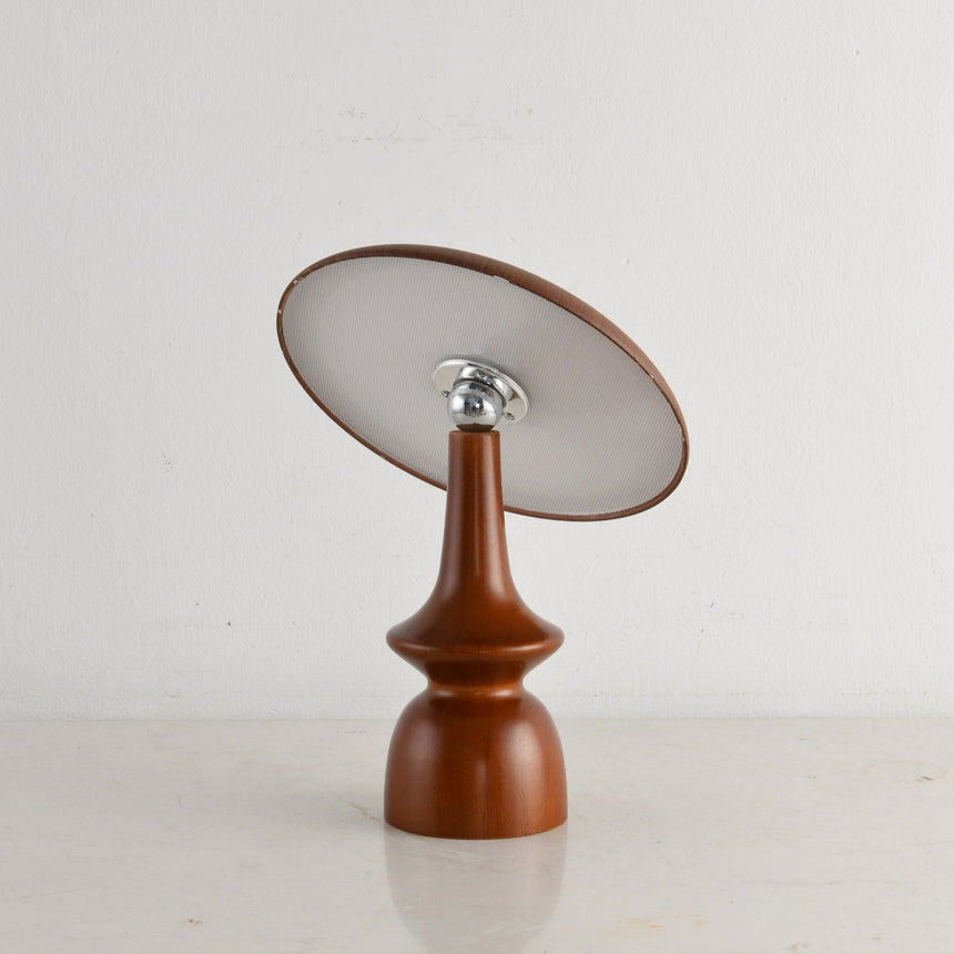 Portable table lamp on a spindle base with the disc tilted