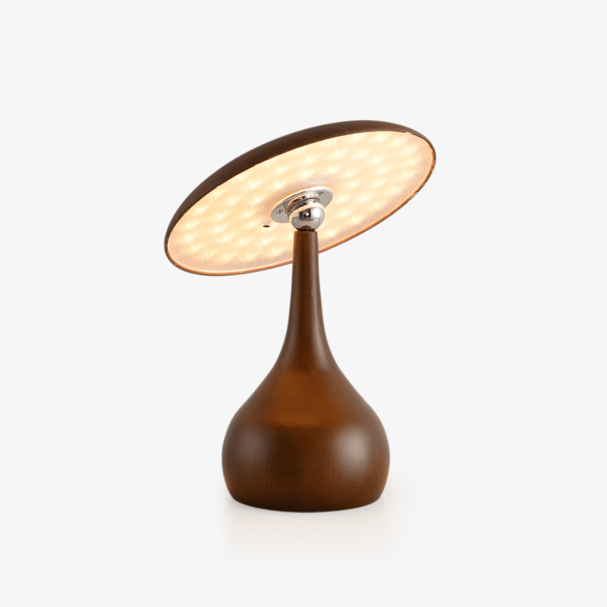 Portable table lamp with a tilting disc on a teardrop wood base