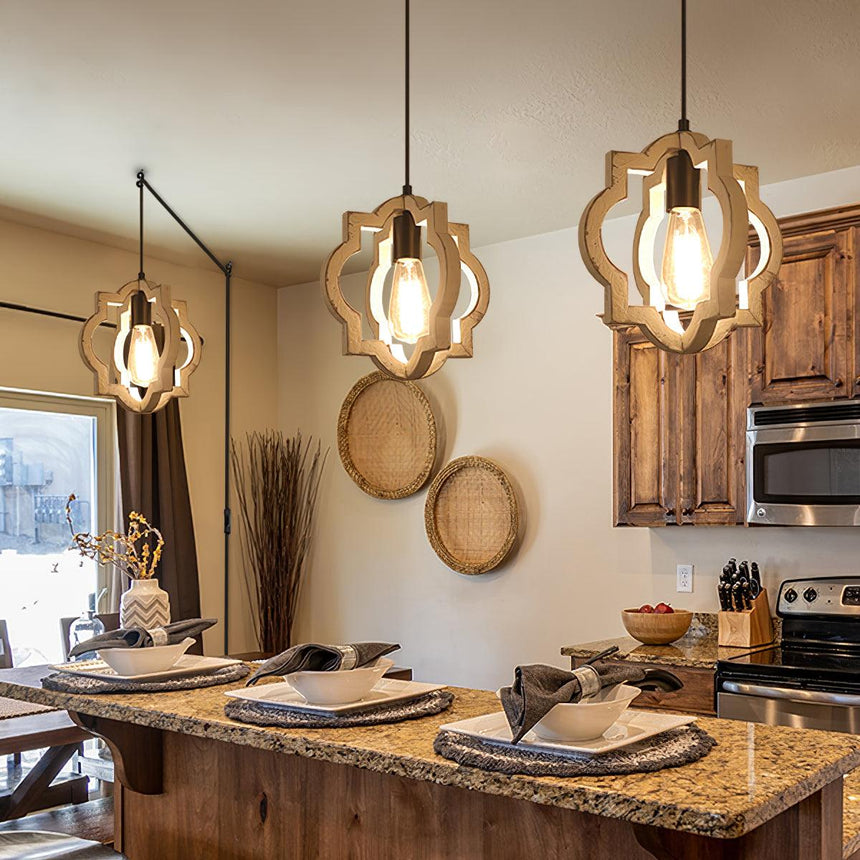 Three of them lit over a granite island in a kitchen with wood cabinets