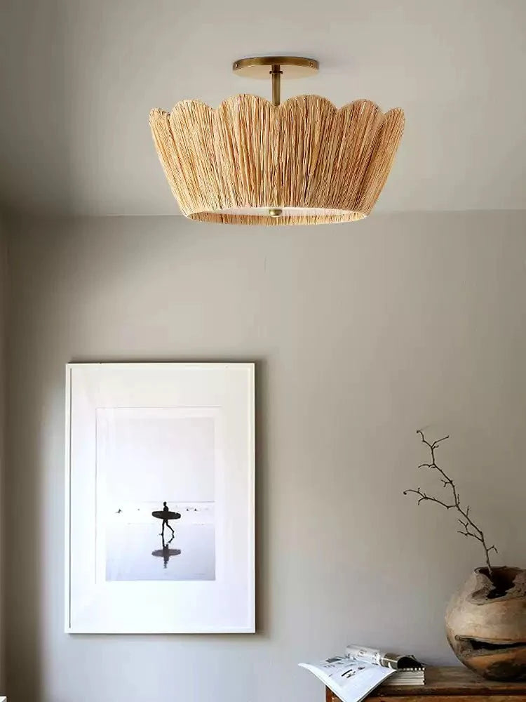 Raffia ceiling light lit near a framed print and a ceramic vase on a shelf
