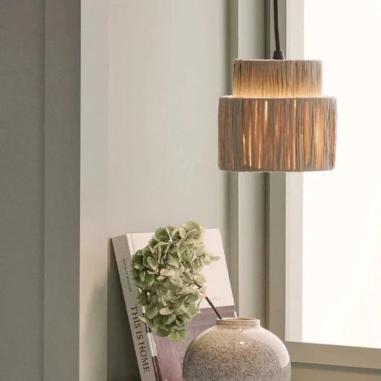 Rattan drum pendant light in a bedroom beside a mirror