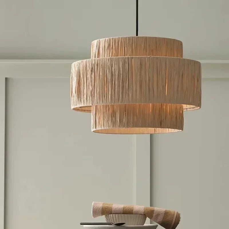 Rattan drum pendant light with a hemp rope fringe lit in a pale room