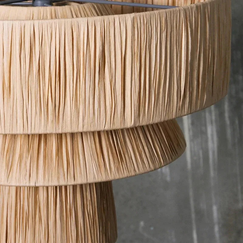 Close view of the woven straw and the hanging fringe of the drum shade