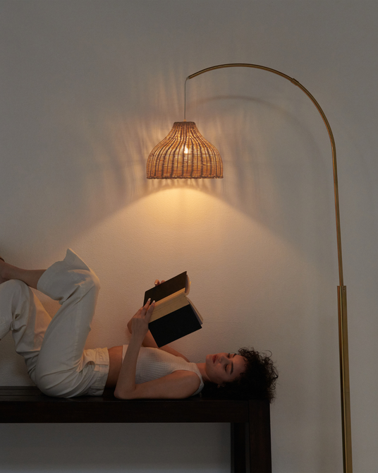 The wicker shade lit warm over a dark wood bench with two readers under it