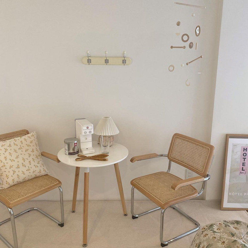 Rattan table lamp on a round table between two cane chairs