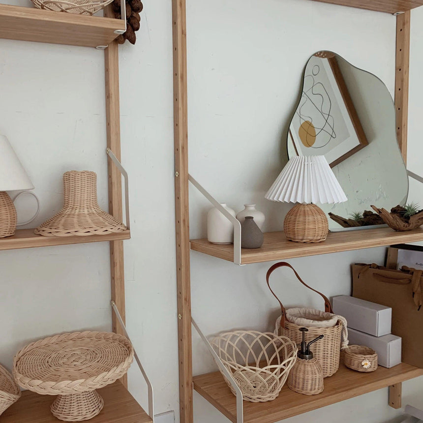 Rattan table lamp on a shelf among woven rattan baskets and trays