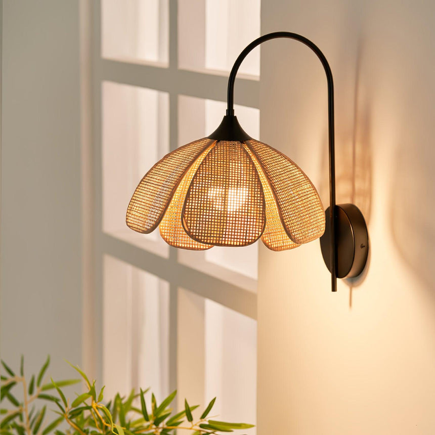 The rattan shade lit beside a window, sunlight falling on the wall