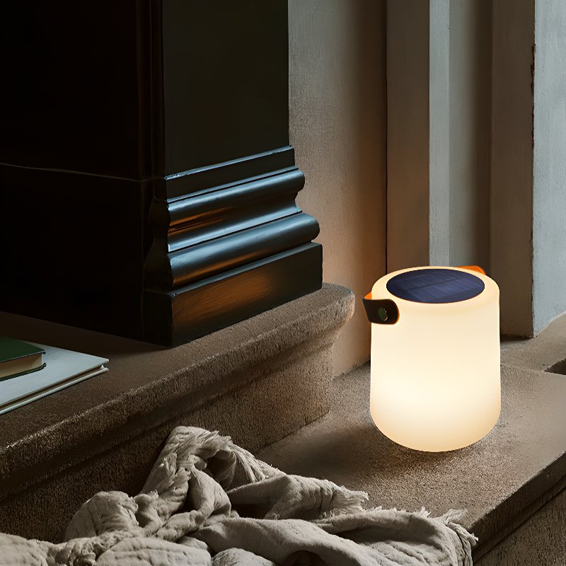 The lamp lit on a stone step beside a doorway with a linen throw on it