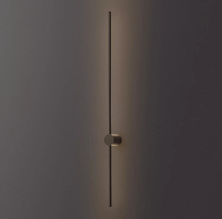The black rod lit against a dark wall, the puck foot holding it clear