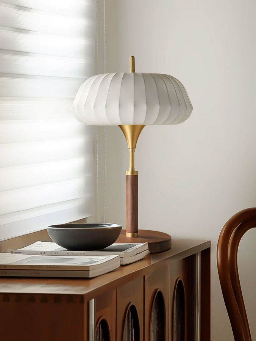 Remote control table lamp lit on a cabinet beside a shallow bowl