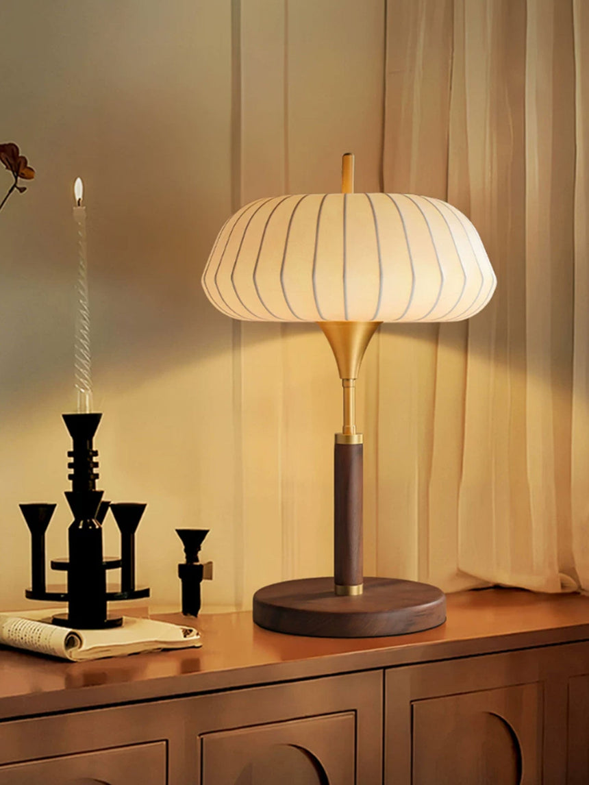 Remote control table lamp lit on a cabinet beside a candelabra