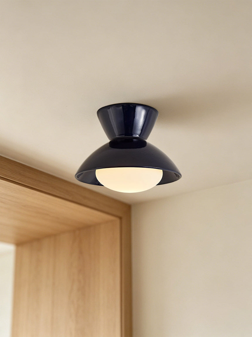 Black gourd ceiling light mounted beside a wood door frame