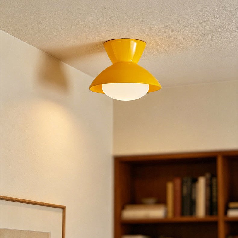 Yellow gourd ceiling light on a sloped ceiling above a bookshelf