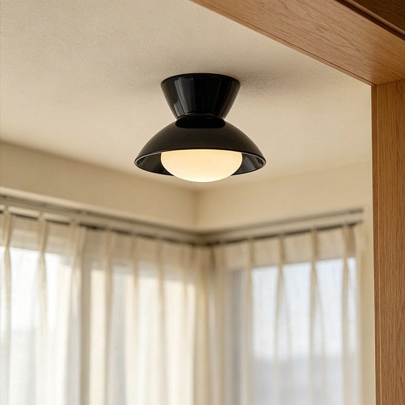 Black gourd ceiling light near a window with full length curtains