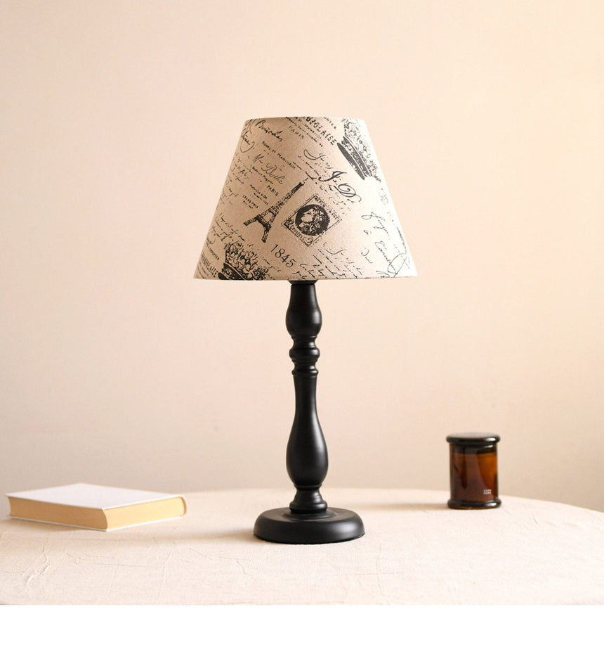 Table lamp with a printed newspaper pattern shade on a black base