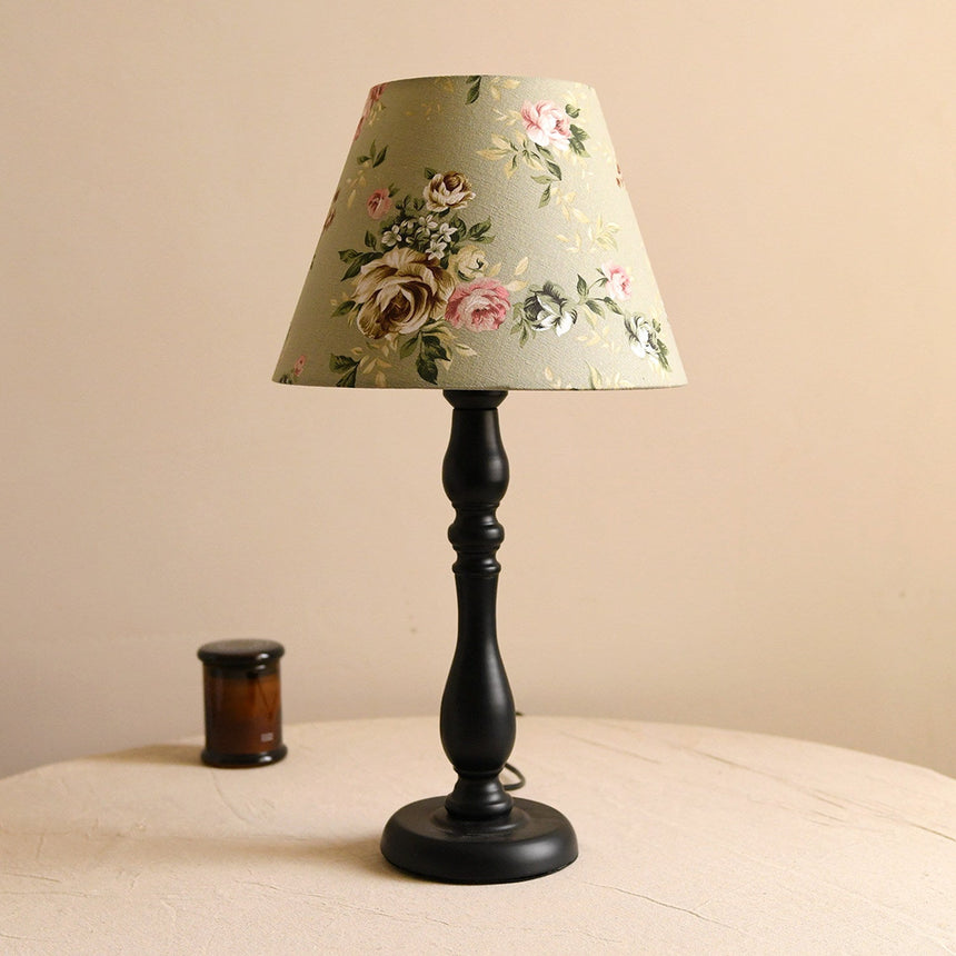 Table lamp with a pea green shade printed with roses on a black base