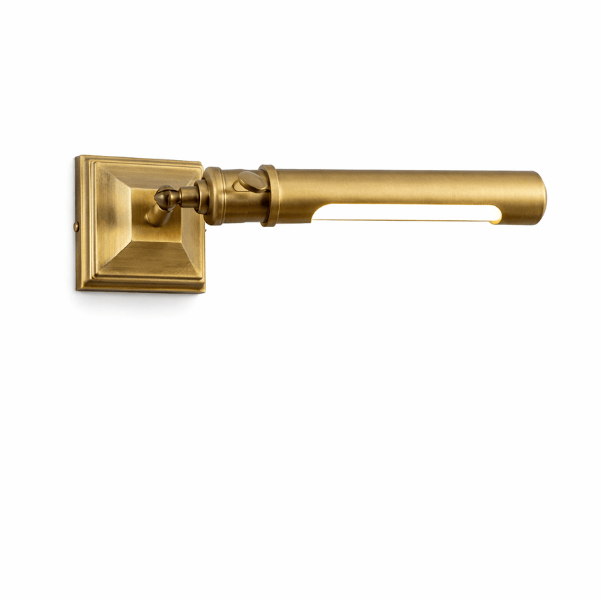 The brass tube seen at an angle, the stepped base square against the wall