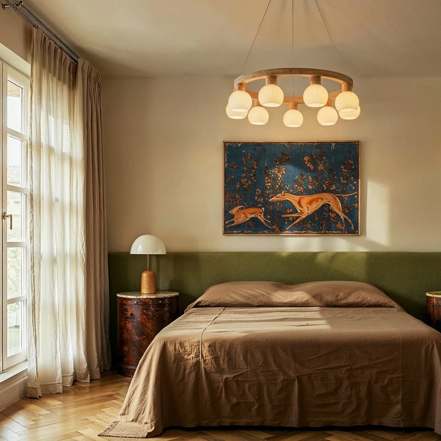 The ring lit above a bed with a framed painting on the wall behind it