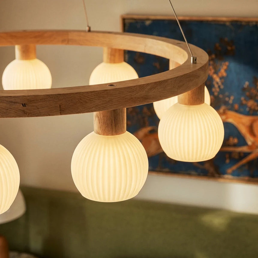 Three lit ribbed globes seen close with a blue framed artwork behind them