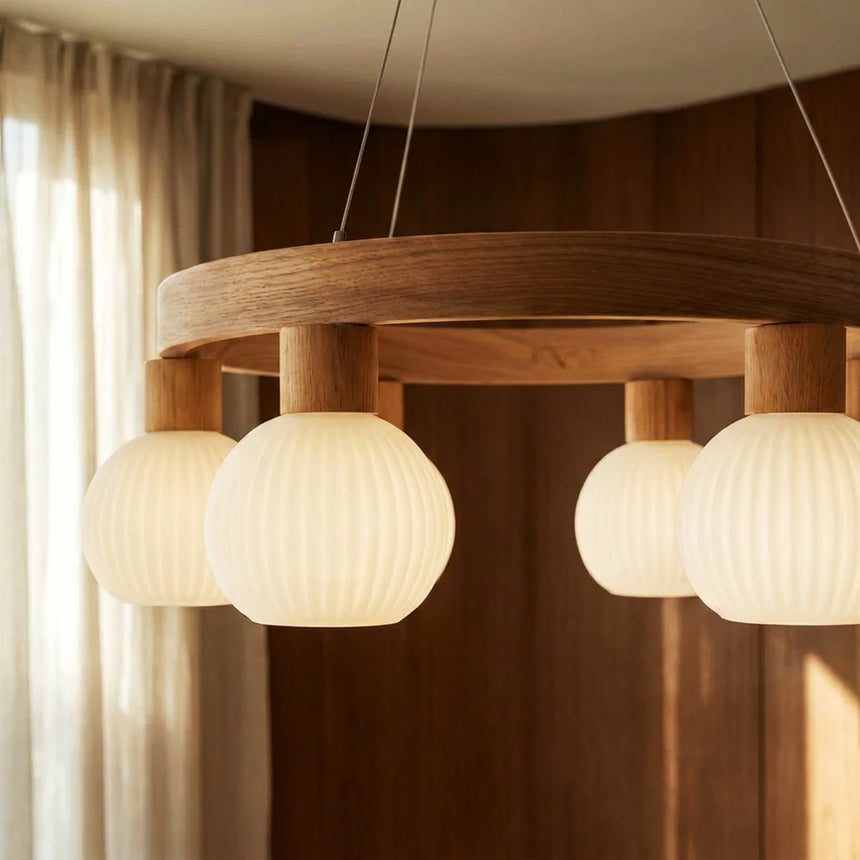 Two lit ribbed globes in front of a dark wood wall, the ring above them