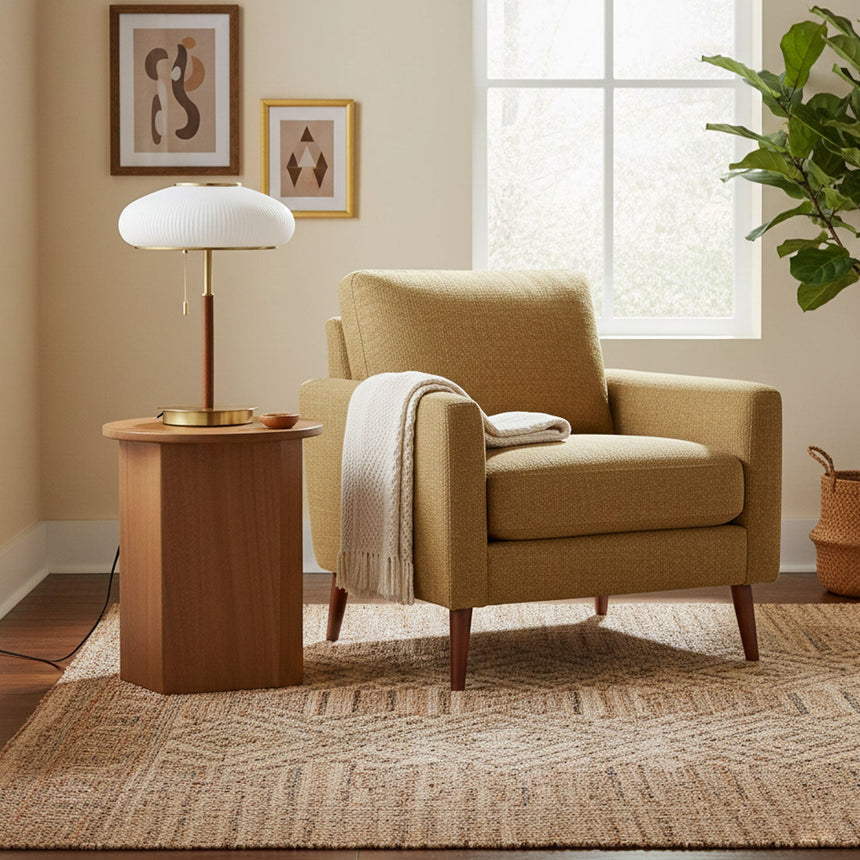 Ribbed glass table lamp lit on a round table beside a green chair