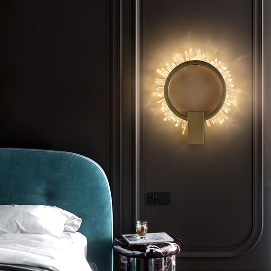 The ring lit beside a teal headboard above a small nightstand