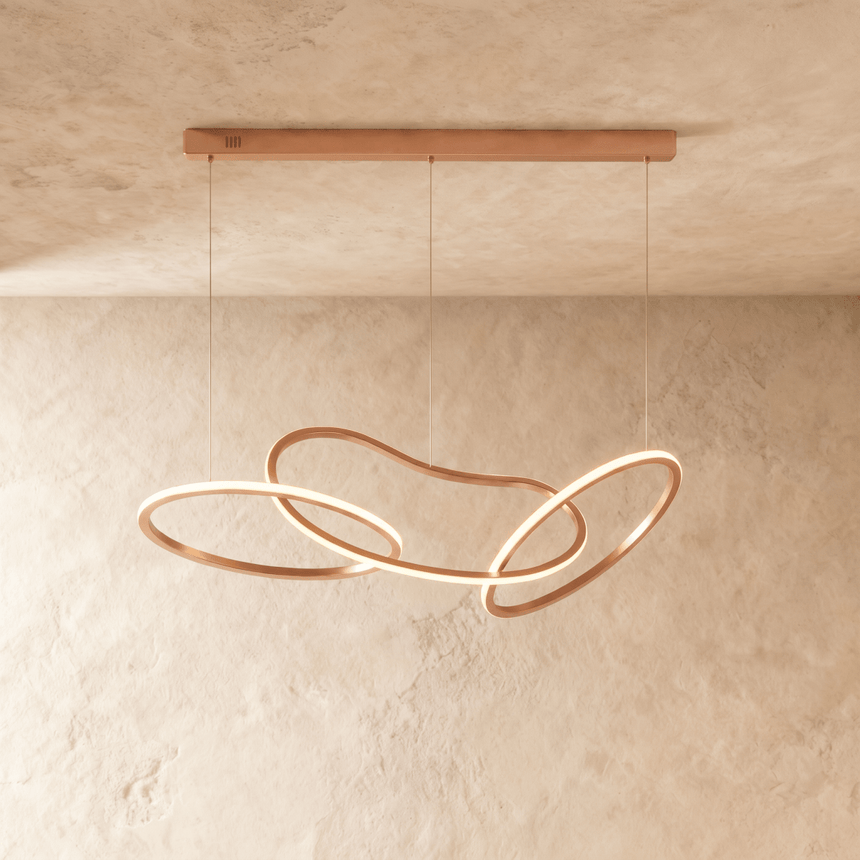 The same interlaced loops in rose gold, lit along the inside of each ring
