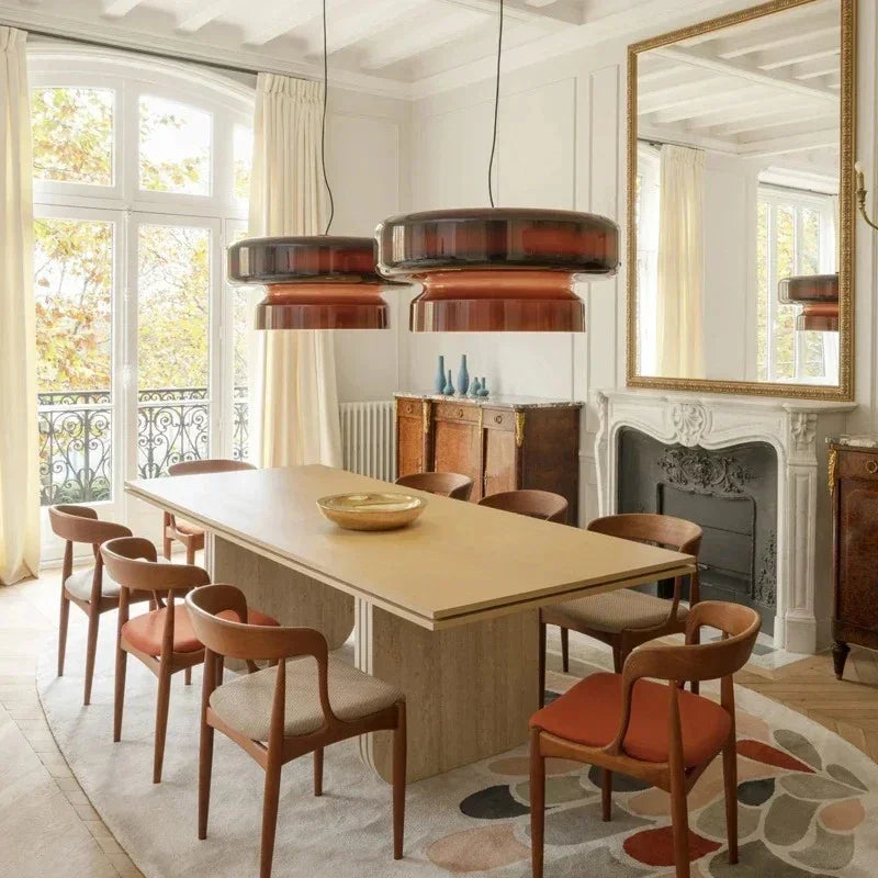 Tinted glass shades above a dining table in a pale room