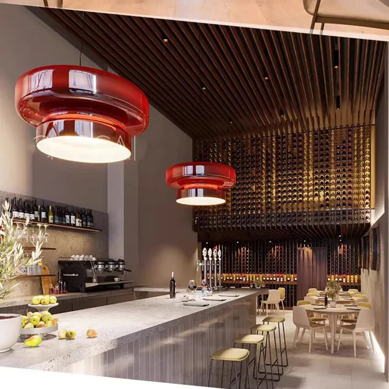 Round ceiling lights in red tinted glass above a bar counter