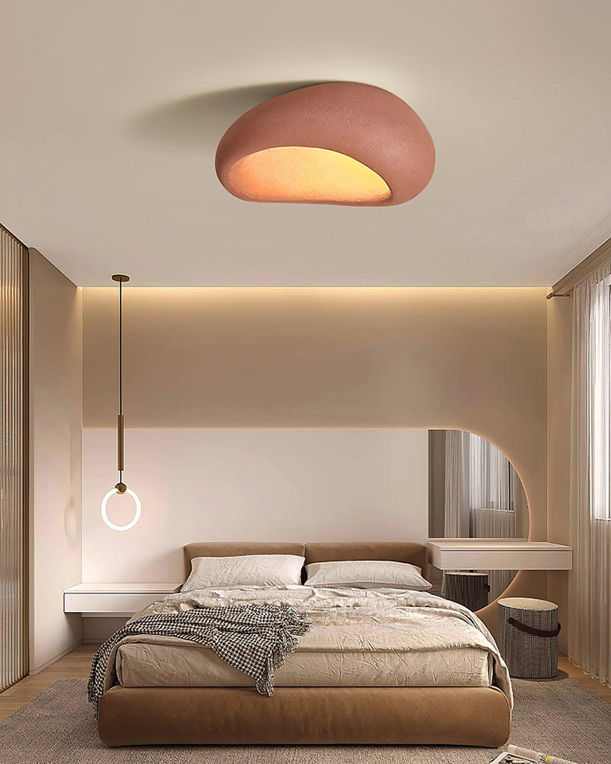 Brick red textured dome ceiling light lit above a bed with a small pendant
