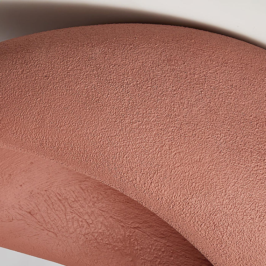 Close view of the brick red textured surface curving away from the opening