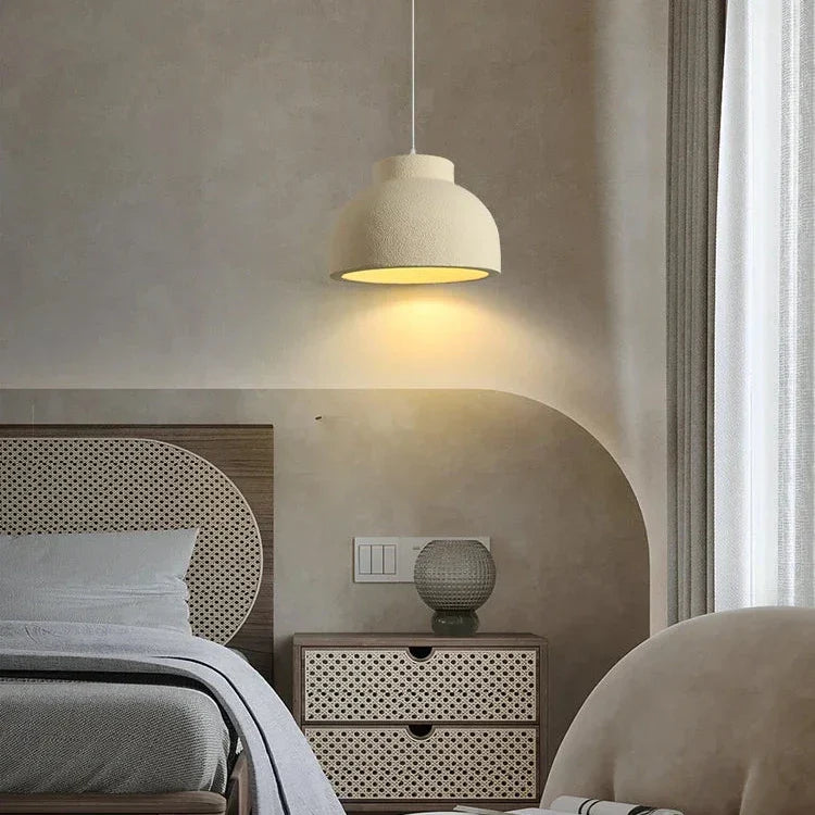 Textured dome lit beside a bed in a warm room