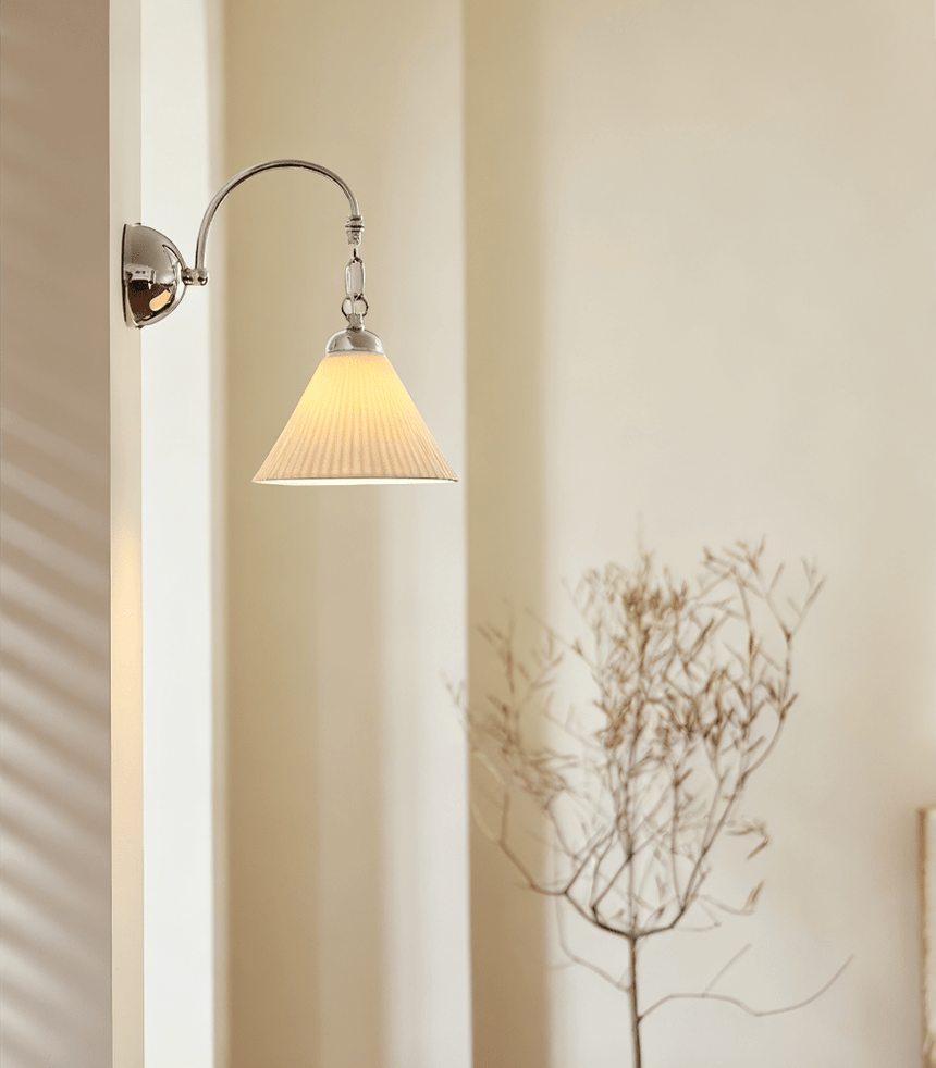 The pleated cone version lit beside a dry branch arrangement