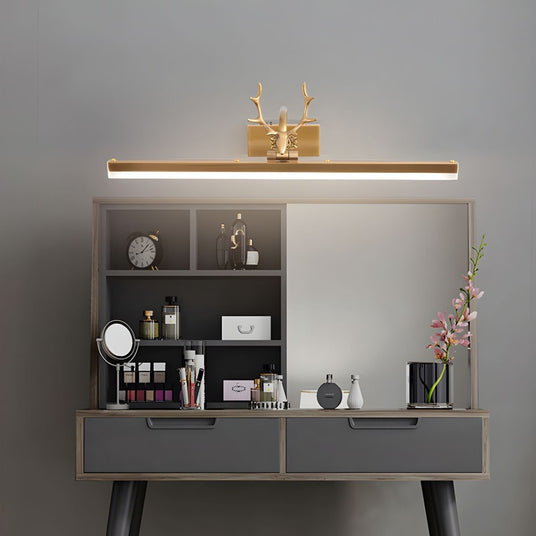 Gold antler bar lit above a dressing table with bottles, brushes and a framed picture