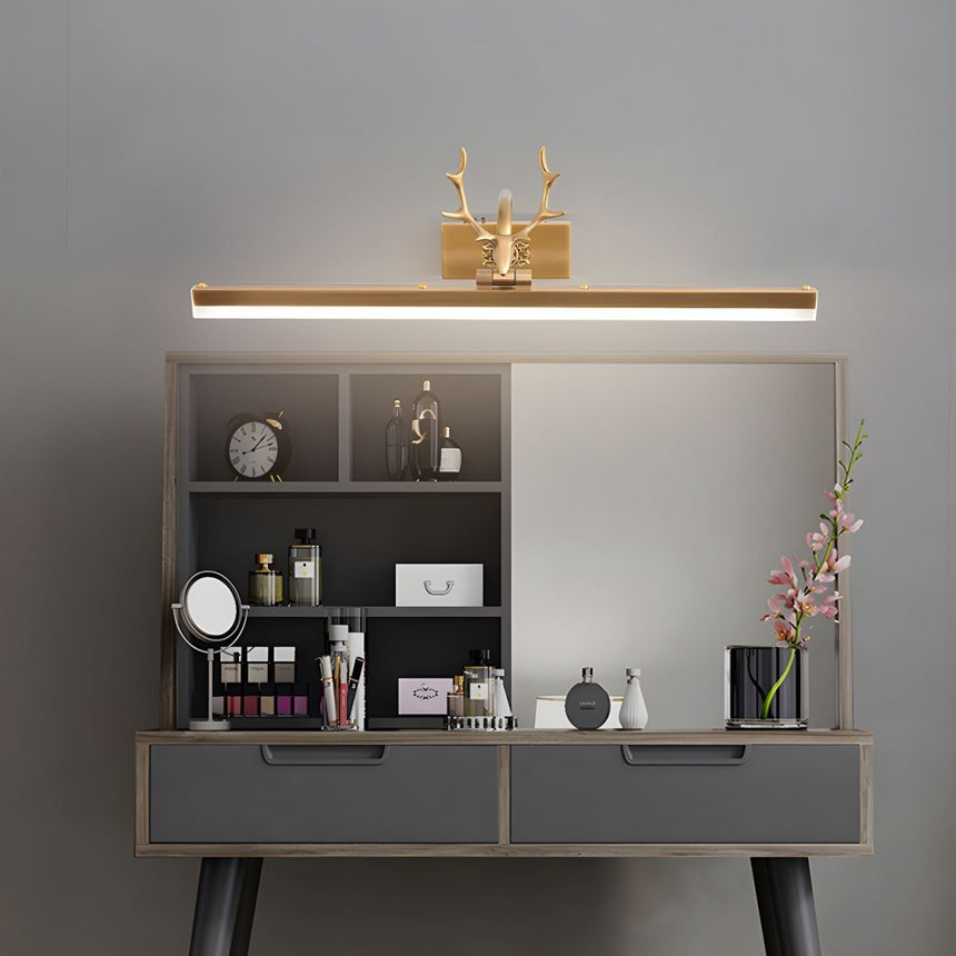 Gold antler bar lit above a dressing table with bottles, brushes and a framed picture